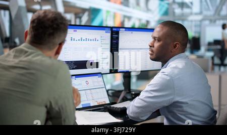 DevOps Engineer Monitors Continuous Delivery Pipeline Status Using Laptop. Stock Photo
