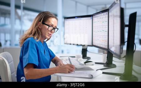 Healthcare Manager Uses CRM Software On Computer To Schedule Patients Efficiently. Stock Photo
