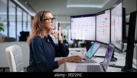 Project Manager Reviews Team’s OKR Progress Carefully Using Laptop Dashboard. Stock Photo