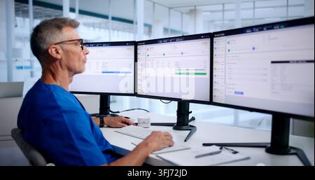 Medical Billing Manager Carefully Reviews Patient Insurance Claims Data On Computer. Stock Photo