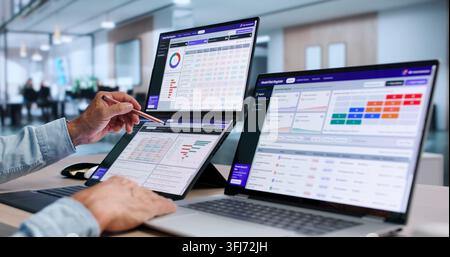 Data Scientist Carefully Monitors AI Risk With Dual Touchscreen Laptops. Stock Photo