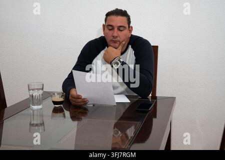 Man concentrating while reviewing important paperwork at a table with coffee Stock Photo