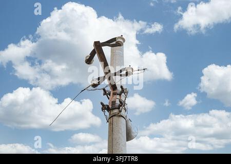 Low angle view of metal brackets at the top of an old concrete utility pole Stock Photo