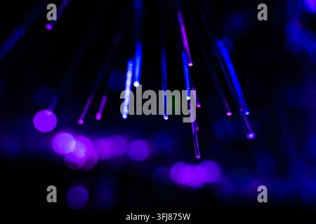 Hanging purple-blue fiber optic lights with cascading light and shadow Stock Photo