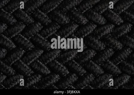 Abstract black knitted fabric textile pattern with dense geometric woven texture background Stock Photo