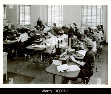 United States, 1950s. Employees of the U.S. Census Bureau operate early alphanumeric keypunch machines used to enter and process statistical data. These machines converted information into punched cards for electronic data processing, forming an important part of the Census Bureau's transition from mechanical tabulation methods toward computer-based data processing. Stock Photo