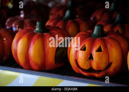 Several colorful ceramic jack-o'-lanterns sit on a supermarket shelf, creating a festive, spooky, and cheerful atmosphere for the upcoming autumn holi Stock Photo