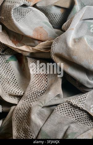 crumpled dirty woven cloth background, rough textile surface with faded pattern in close-up view, rustic fabric texture in full frame Stock Photo