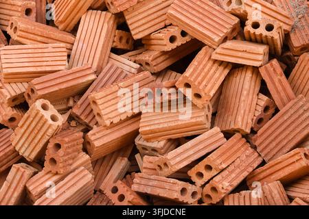 A stacked terracotta hollow brick with ridged surface and circular openings showing construction material texture and warm earthy color Stock Photo