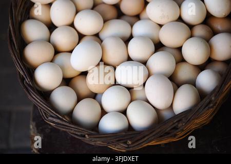 Basket filled with eggs at a market on a sunny day Stock Photo