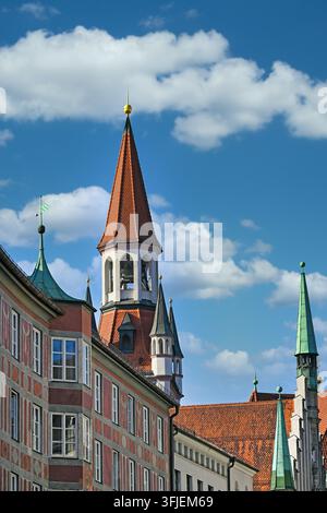 Scenic vertical view of the iconic spire tower of the Old Town Hall (Altes Rathaus) peaking above historic traditional buildings with highly decorated Stock Photo