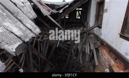 Flight into destroyed house after hurricane in american town at night. Homeless family story after broken roof and wall of home. Drone shot. Climate c Stock Photo