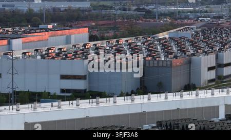 Aerial close up of data center rooftop in Ashburn, Virginia, USA, showing dense rows of cooling units and power infrastructure illuminated by warm sun Stock Photo