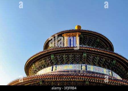 Low-angle view of the ornate roof and golden finial of the Hall of Prayer for Good Harvests at the Temple of Heaven, Beijing, China. Stock Photo