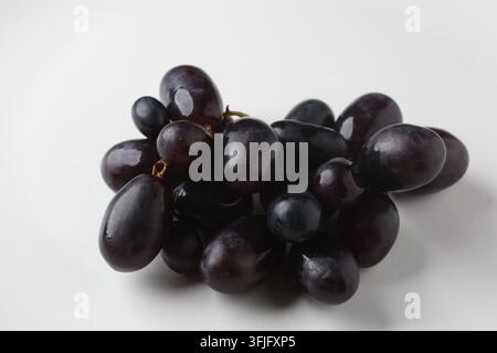 Fresh Cluster of Ripe Dark Red Grapes Isolated on Plain White Background Stock Photo