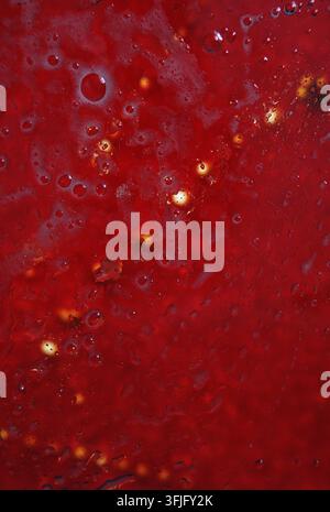 Macro shot of a red background featuring liquid bubbles and blurred lights. High quality photo Stock Photo