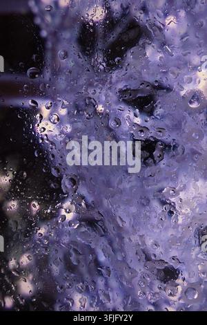 An abstract texture featuring water droplets or a frost pattern on glass in shades of purple. High quality photo Stock Photo