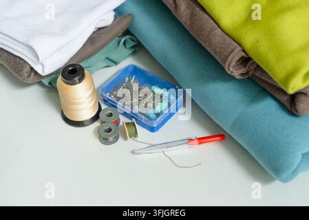 Sewing project materials prepared on white craft workspace. Fabric and sewing kit laid out for creative inspiring hobby work. Crafting supplies assembled for productive textile DIY creation Stock Photo