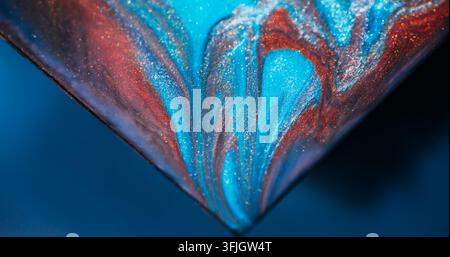 Shimmer paint. Sparkling fluid. Defocused blue orange purple color triangle marble mix texture spilling on abstract art background. Stock Photo