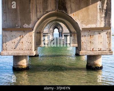 View of concrete bridge piers with arched openings extending over the sea in Pohang-si, Gyeongsangbuk-do, South Korea. Stock Photo