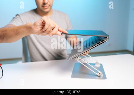 Focused professional finishing work. Close-up on hands and portable computer. Modern workspace with cool blue lighting and minimalist aesthetic Stock Photo