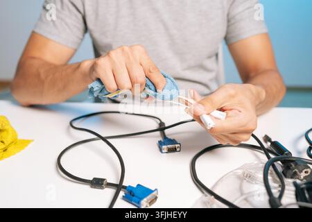 Concept of decluttering, electronic maintenance and digital hygiene. Person tidying up messy cords and connectors for recycling, reuse. Tidying Stock Photo
