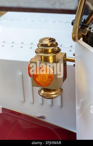 Close-up of a vintage brass vehicle lamp with an amber lens and polished metal details. Stock Photo