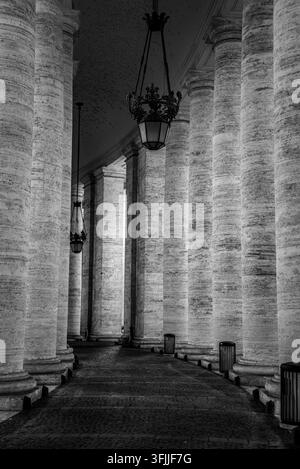 An architectural composition looking down the long covered corridor of berninis massive stone columns located in vatican city, rome, italy Stock Photo
