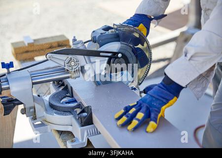 Man using a Sliding Miter Saw to cut Wood Stock Photo