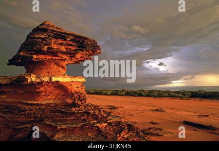 WARM LIGHTING AND A DRAMATIC SKY OVER THE ROCKY MANGROVE-LINED CRAB CREEK, ROEBUCK BAY, BROOME, WESTERN AUSTRALIA. Stock Photo