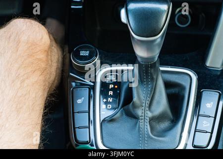 Close-up of an automatic transmission gear stick in a modern car, showing gear selector PRND and control buttons inside vehicle Stock Photo