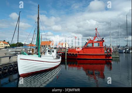 Fishing boats and a pilot boat docked in a harbor Stock Photo