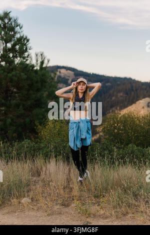 Stylish woman in sports gear poses on a hiking trail Stock Photo