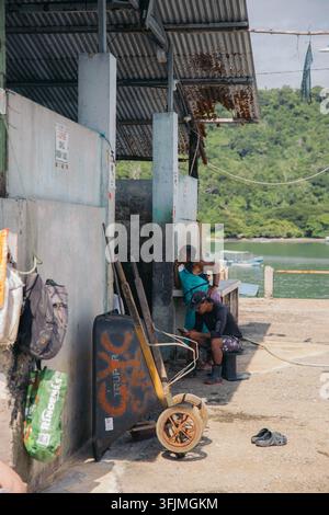 Two men taking a break at a rustic dockside Stock Photo