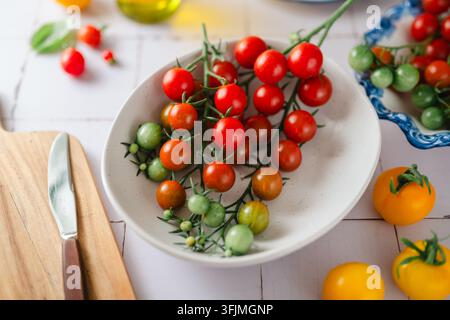Colorful cherry tomatoes on a bright white kitchen counter Stock Photo