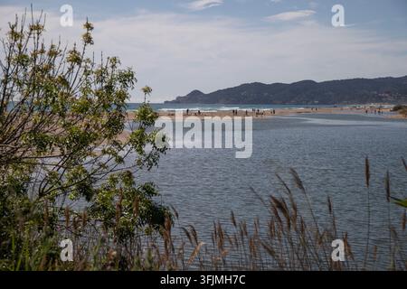 River mouth meeting ocean at sandy beach Stock Photo