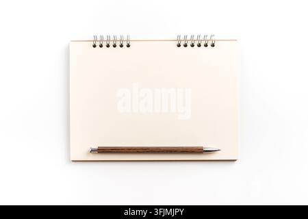 Top view of blank spiral notebook mockup with pen on white background with copy space Stock Photo