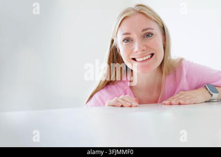 Smiling blonde woman with copy space, ideal for advertising happiness, wellness, customer service and a friendly brand message. Stock Photo
