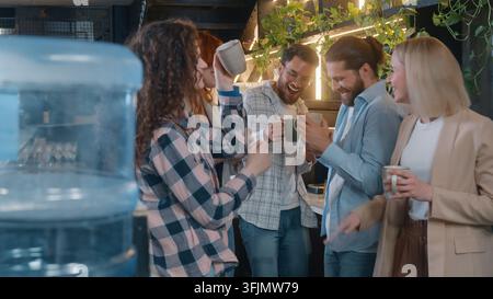 Cheerful diversity people five friends business team men women dancing drinking coffee in office cafe laughing enjoying dance listening music together Stock Photo