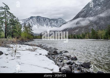 A Serene and Beautiful Winter Landscape Featuring SnowCapped Majestic Mountains and a River Stock Photo