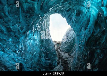 View of the vibrant blue ice walls inside the Jokulsarlon ice cave, with intricate glacial textures and natural light in Sveitarfelagid Hornafjordur, Stock Photo