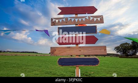 Colorful wooden directional sign in a rural field Stock Photo