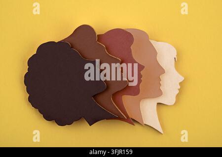 Group of paper silhouettes of human heads in various skin tones. Communication and relationship concept. Stock Photo