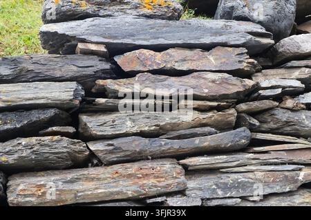 Detailed background texture of an old masonry wall built with grey and brown natural slate stones Stock Photo