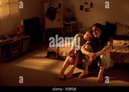 Romantic Couple Resting on Floor in Cozy Bedroom at Home Stock Photo
