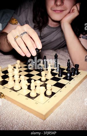 Man Playing Chess Game on Floor during Leisure Time at Home Stock Photo