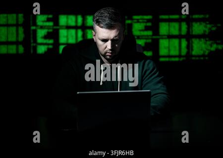 Network security specialist uses laptop. Network security specialist monitors cyber attack. Network security specialist analyzes code screen. Network Stock Photo