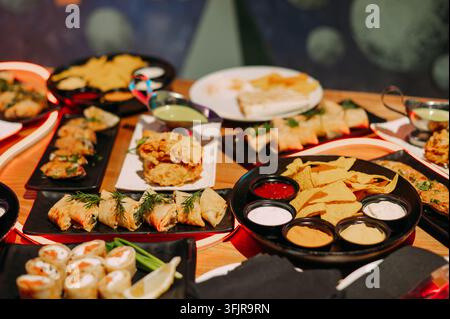 Assorted appetizers and dipping sauces served on a restaurant table Stock Photo