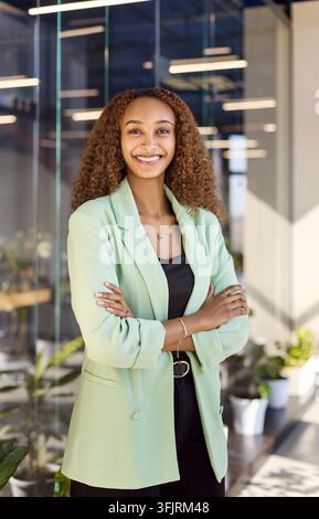 Confident businesswoman portrait in modern office, smiling manager in green blazer Stock Photo