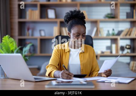 Financial analysis and business planning, woman working on laptop and reviewing documents at desk in office for corporate accounting and professional management tasks. Employee managing data. Stock Photo